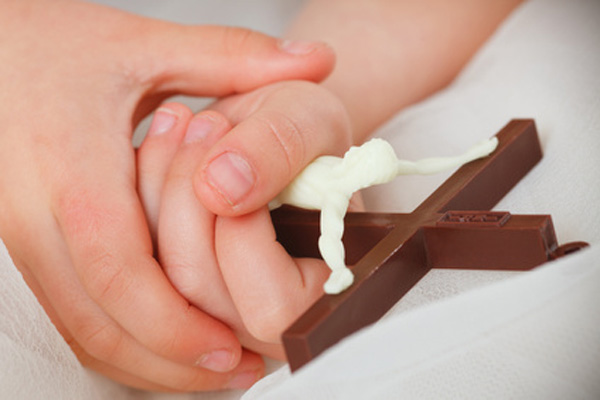 Kinder und Erwachsenen Hand die ein Kreuz halten