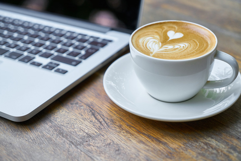 Laptop mit Tasse Kaffe